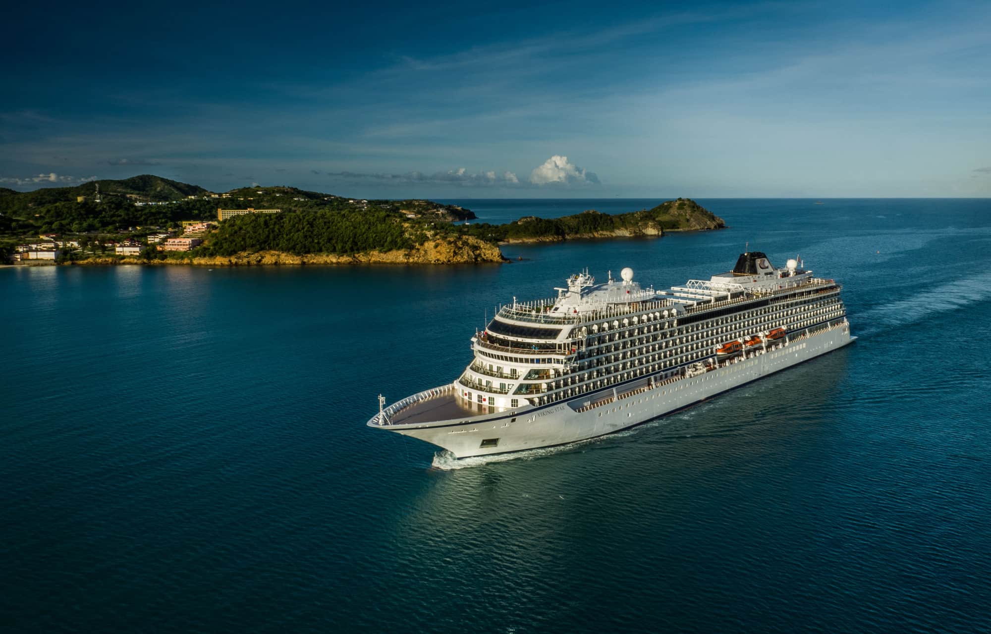 A cruise ship sailing past a dramatic, fjord landscape in Norway